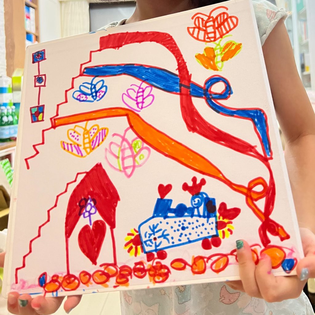 孩子拿著自己完成的畫作